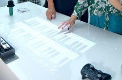极米触屏投影首次亮相 可在桌面操控虚拟钢琴